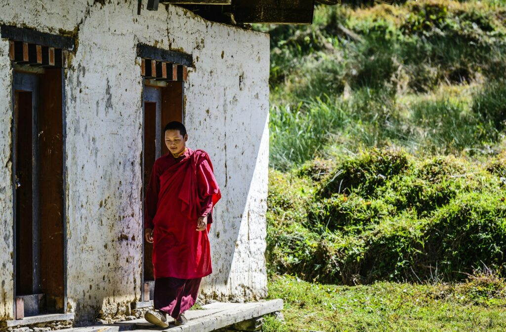 Asian monk walking by monastery doors